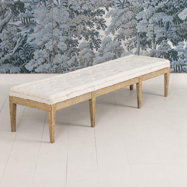 This is a richly carved 19th century Swedish Gustavian period bench, newly upholstered with a hand-stitched, tufted linen...