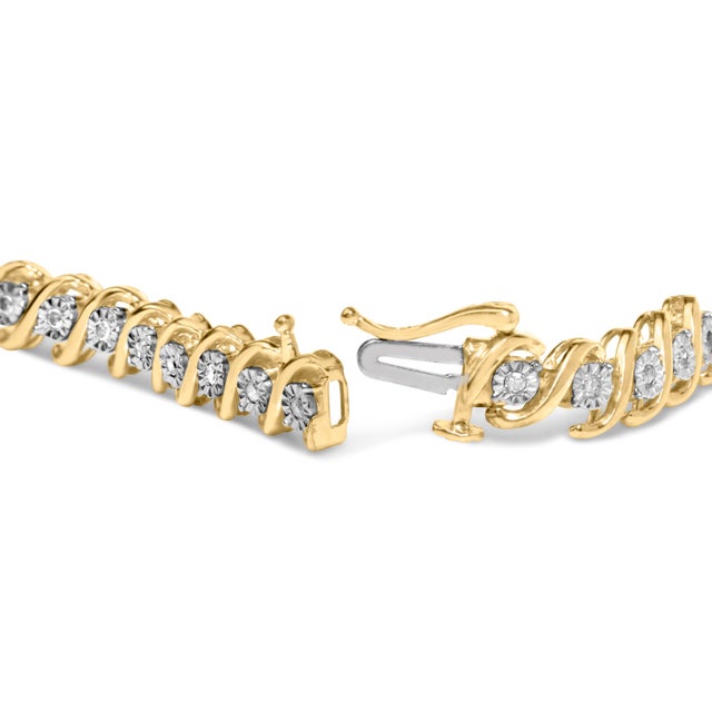 The pinnacle of high style, this fascinating tennis bracelet dazzles with round diamonds designed with a unique, stone...