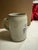 Set of two mugs. 1. Hofbräuhaus (HB) 1-Liter Lidded Stein: Features the classic blue crowned HB logo on a traditional gray...