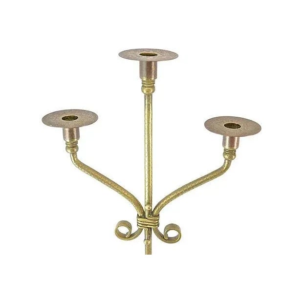 A unique pair of antique early 20th century brass three light candle holders, hand wrought with twisted stems, ornately...