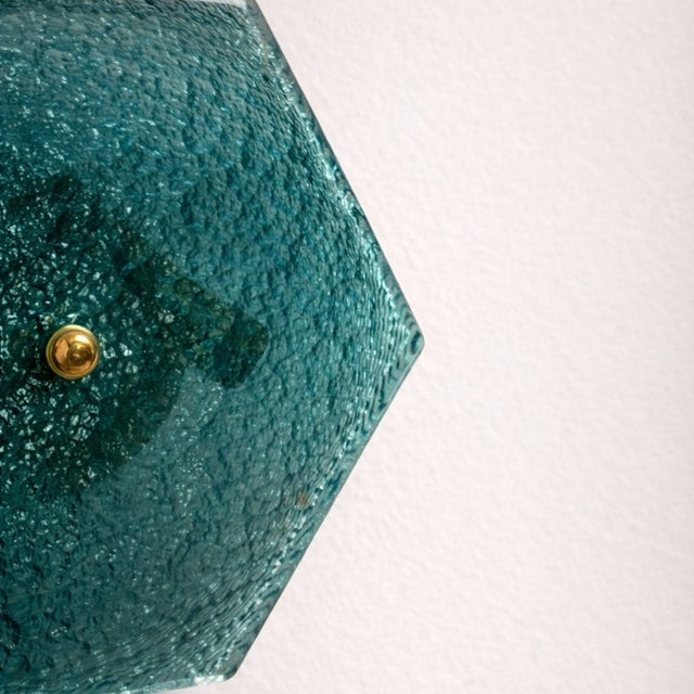 This beautiful pair of wall lights features a cylindrical gold base topped with a hexagonal turquoise glass shade. The...