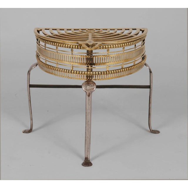 Antique brass and iron half-round pierced trivet on tall legs with penny feet. Great to use as a drinks stand next to an...
