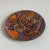 Enameled trinket dish in shades of orange, purple, and light brown. Made by Bea (artist’s seal on bottom).