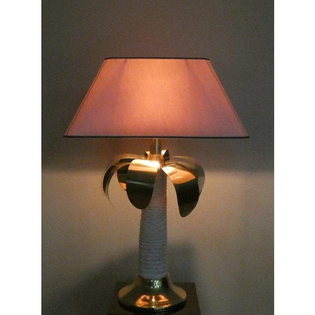 This lamp is a vintage design piece from the 1970s. It features a tropical, glamorous, and luxurious style, typical of the...
