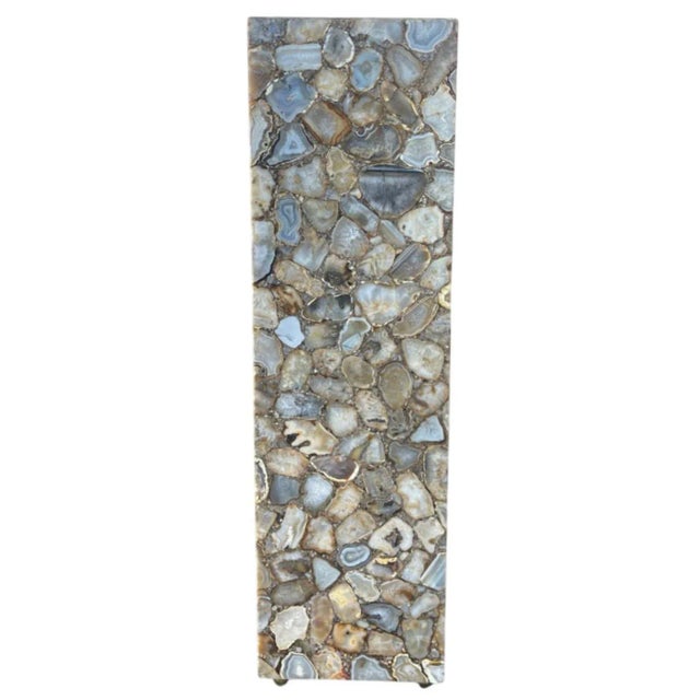 A striking pair of 20th-century column pedestal featuring a breathtaking composition of polished agate slices, expertly...
