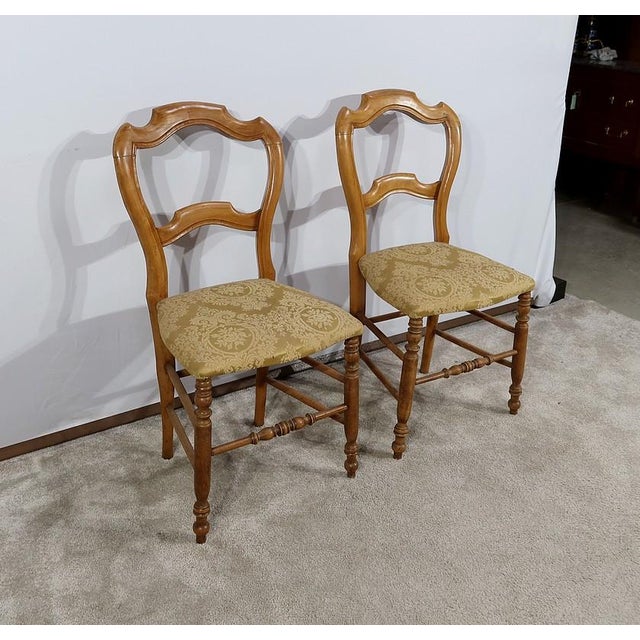 Pair of Louis-Philippe chairs in solid beech resting on shot feet, connected by a also turned bar. The "saber" feet at the...