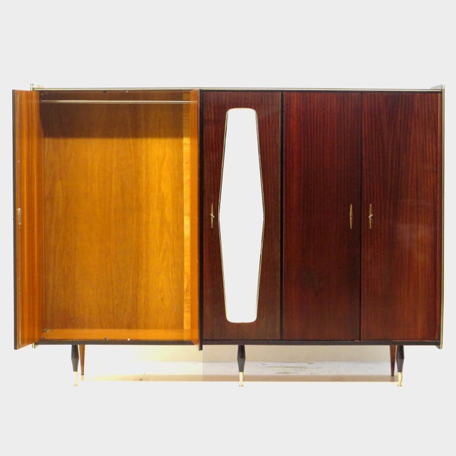 Vintage mid century 5-door wardrobe in teak from the 1960s. This large wardrobe rests on stylish legs with brass details,...