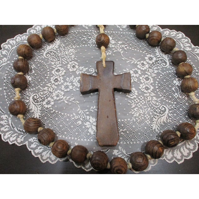 The product is a giant wooden rosary, featuring large wooden beads that have been hand-carved and hand-knotted. This...