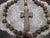 The product is a giant wooden rosary, featuring large wooden beads that have been hand-carved and hand-knotted. This...
