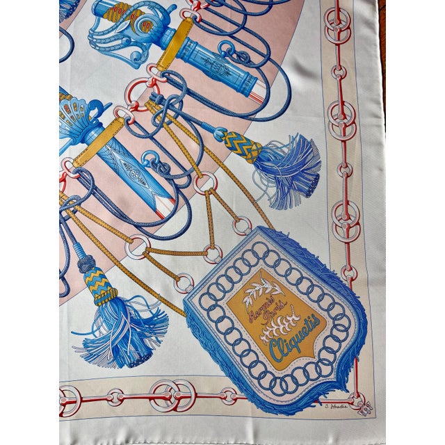HERMES CLIQUETIS 2018 silk scarf This pale pink and bright blue scarf depicts a series of military sabers. Featuring...
