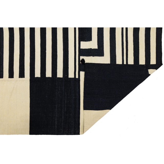 Elevate your space with this striking modern Navajo-style flat-weave wool rug, featuring a sophisticated high-contrast...