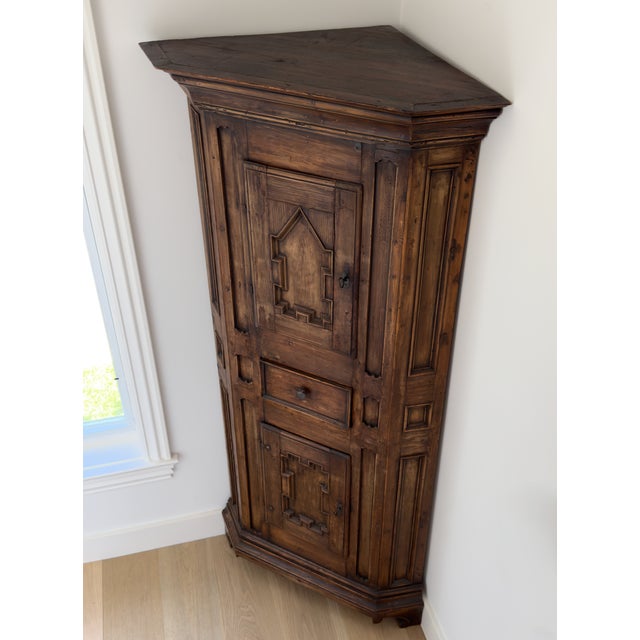 This is an early nineteenth century antique pine corner cabinet, circa 1800. It has two paneled cabinet doors and a middle...