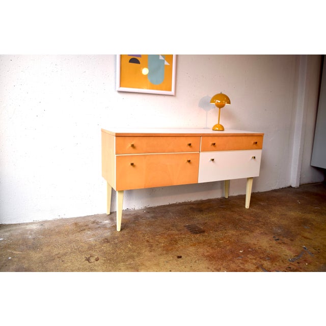 This simple sideboard is an original piece from the 1960s. The cabinet features genuine birch veneer. The light accents...