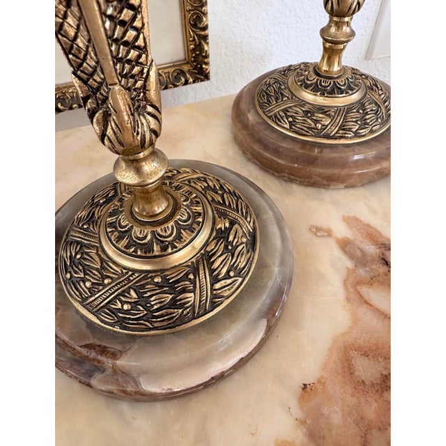 Substantial pair of vintage three-arm candelabra featuring richly ornamented brass-tone metalwork and polished natural...