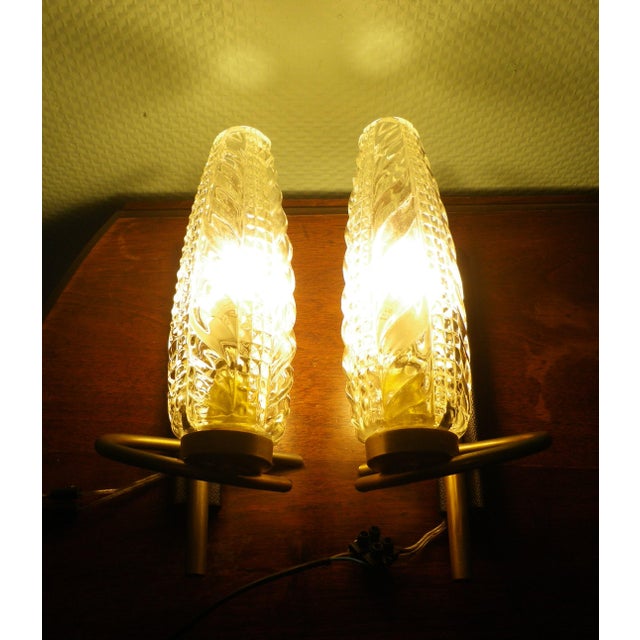 Two 1950s wall sconces Gold-tone metal wall bracket with black faux leather cover Gold-tone metal sconce brackets The...