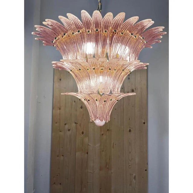 Chandelier made with pink “palmette” elements of murano glass with a gold 24k metal brass finishing that give a thouch of...