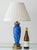 A Bohemian art glass lamp: a two-tone blue blown body seated on a cast brass foot worked with leaves and tendrils, with a...