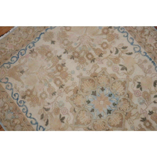 A fine quality mat size Persian Kashan rug with a fancy formal motif in ivory, beige, brown, and blue, circa 1950....