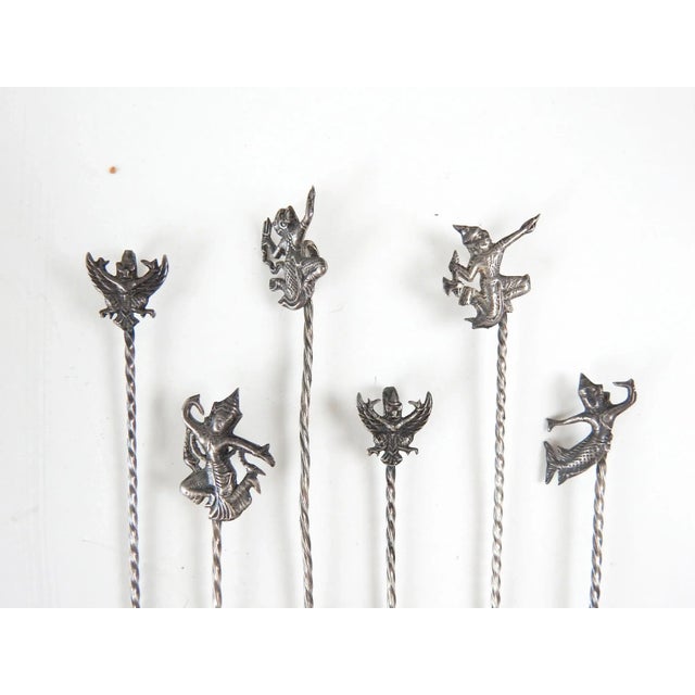 Set of 6 vintage sterling silver cocktail picks from Siam. Each is 3.5" long. Overall patina.