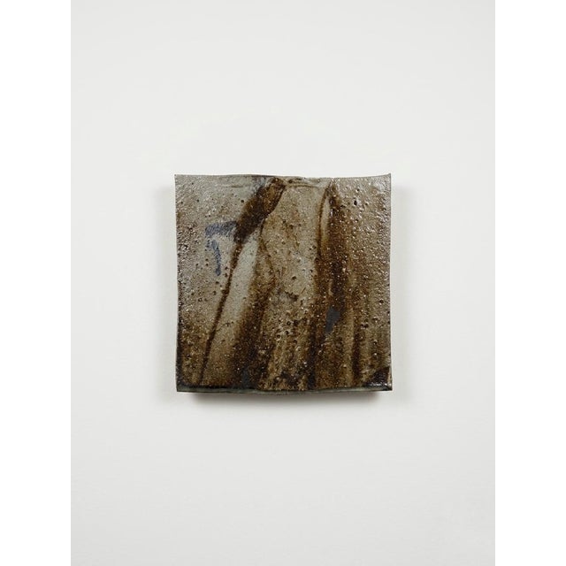 This handmade ceramic wall art tile is created as a decorative bu sculptor Tina Shenk. This art object designed to be hung...