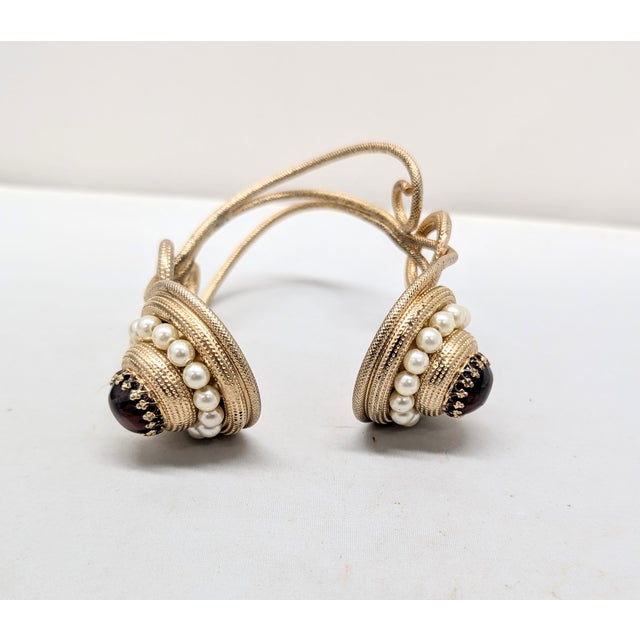 1950s goldtone two round sections with prong set cabochon faux-garnets surrounded by faux-pearls with loopy textured wire...