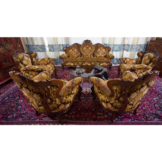 Representative Italian sofa set in neo-baroque style, consisting of a three-seater sofa and four separate armchairs. The...