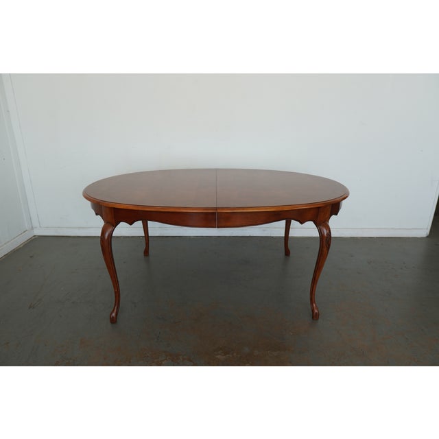 This vintage Baker Furniture dining table embodies classic French Provincial style with its graceful cabriole legs, softly...