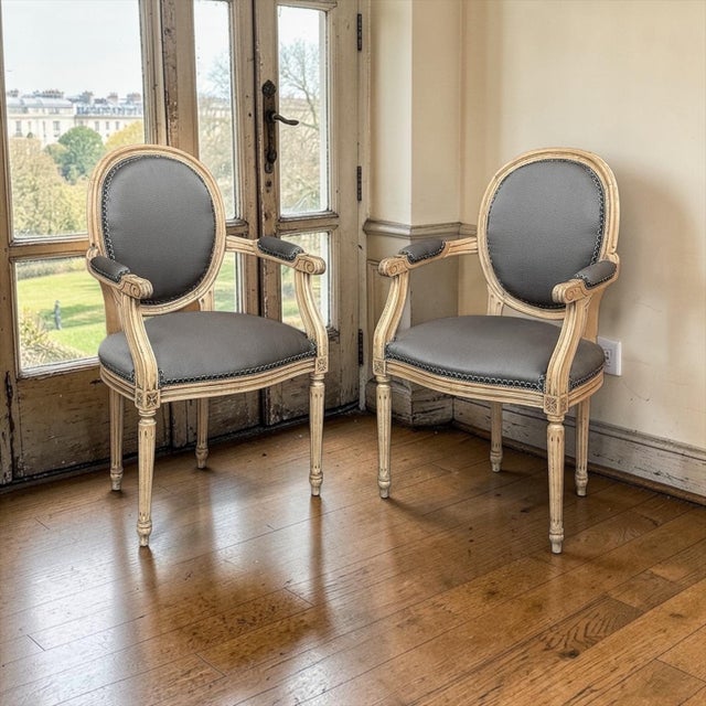 Elegant pair of Louis XVI style armchairs features the classic medallion (oval) backs so beloved of the neoclassical...