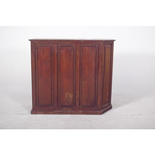 Wooden bar cabinet. with a dark, robust finish, the front is closed, with four embossed panels, giving it a classic, sober...