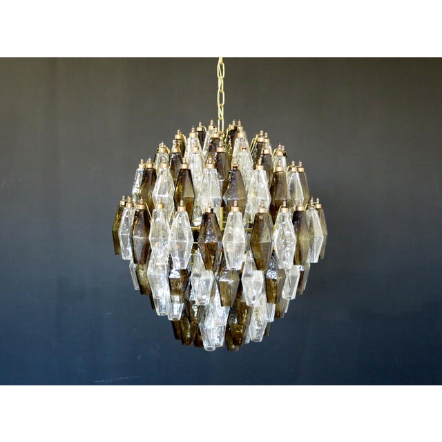 Elegant Italian pendant light made from 140 trasparent and "smoked" Murano glasses "poliedri". Structure in gold and brass...