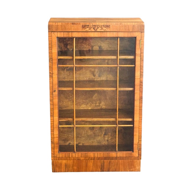 A fine period Art Deco Era display cabinet or bookcase from England, circa 1930s, featuring a beautiful veneer surround of...