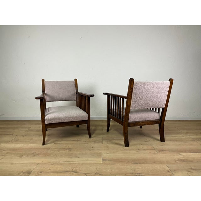 Pair of armchairs with a finely crafted wooden frame and pink boucle upholstery, made in Italy in the 1940s. The armchairs...