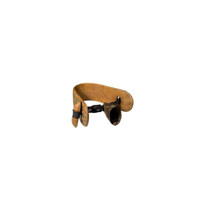 A bell collar, featuring a curved wooden band decorated with carvings and paintings. A traditional item of rural...