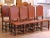 Crafted in Spain circa 1880, this complete set of eight antique dining chairs combines sturdy oak construction with richly...