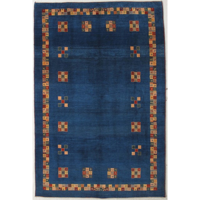 Vintage Hand-knotted Persian Lori Gabbeh rug featuring a deep indigo field with scattered geometric medallions and a...