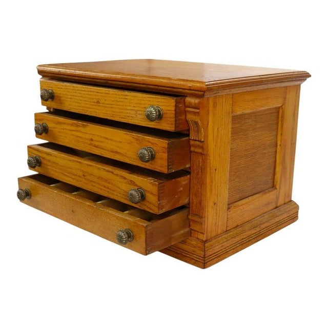 An antique J & P Coats attr spool cabinet, crafted from oak and dating to approximately 1900. This cabinet features four...