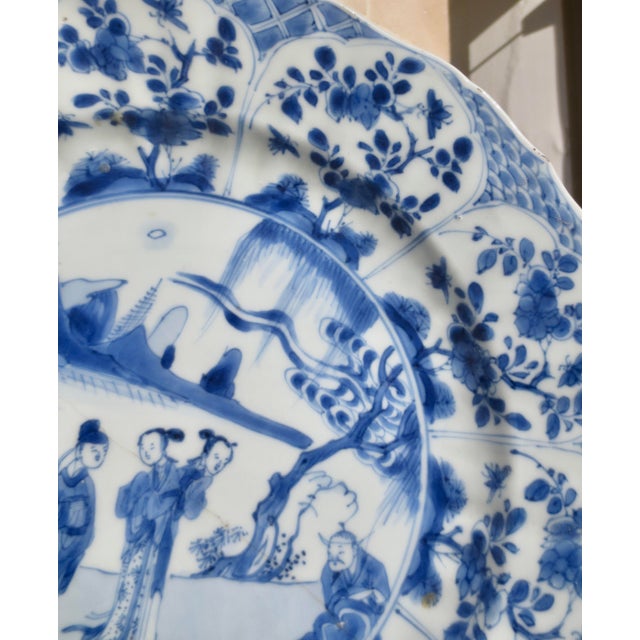 Chinese blue-and-white plate, late Kangxi (1662-1722), of moulded form with a barbed rim, the central roundel scene...