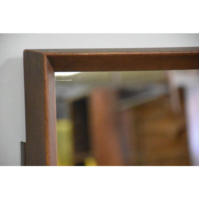 A mid century modern mirror. Comes with removable brackets to attach to a dresser. Originally a piece from an American of...