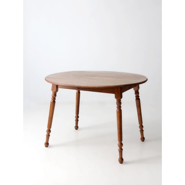 This vintage mid-century Dearborn Co dining table features beautifully turned legs, classic drop leaves, and two removable...