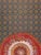 An English needlepoint carpet from the turn of the 20th century. A rosette wreath medallion serves as the focal point...