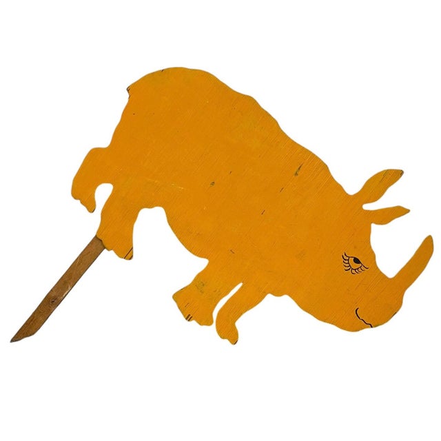 This decorative vintage wooden rhinoceros cut-out is hand-painted in a warm yellow tone and designed as a yard or garden...