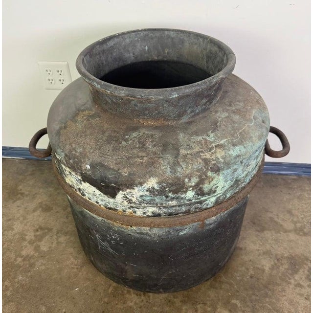 A striking antique copper storage vessel, hand-forged with a beautifully timeworn surface and rich verdigris patina. This...