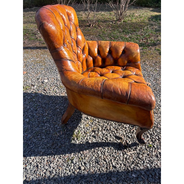 A late 19th/early 29th century English Tufted Leather Library Chair in Butterscotch leather, the curved back with heavily...