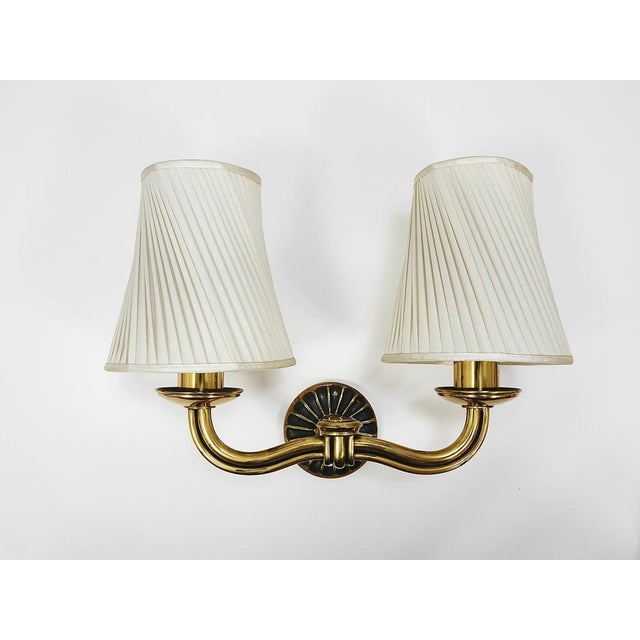 This exquisite pair of two-armed wall lights exemplifies the elegance of Viennese Modernism from the 1940s, designed by...