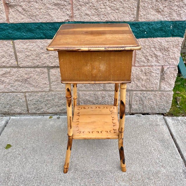 Vintage British Colonial style bamboo side table with flip top storage and lower shelf.