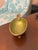 A beautifully detailed vintage ashtray by Evans featuring a rich olive green marbled enamel bowl framed by ornate brass...