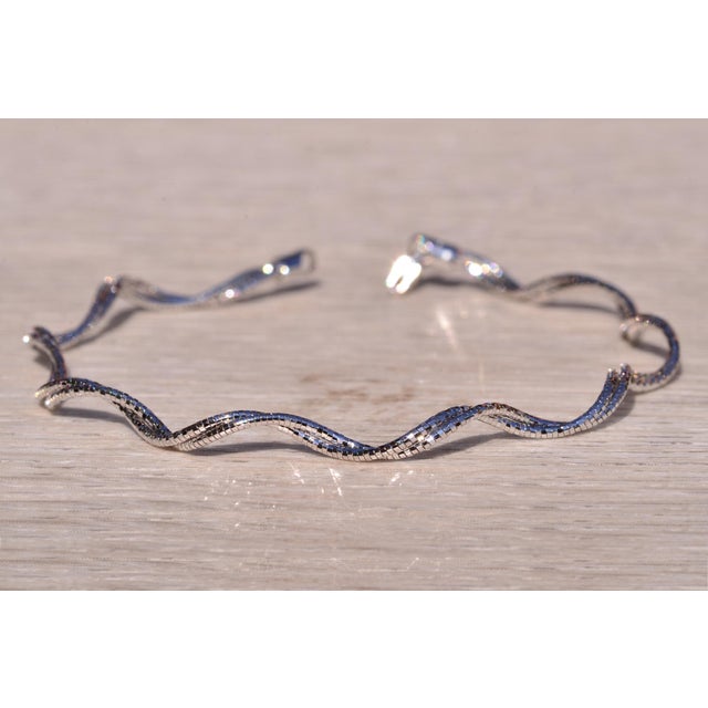 The 76th Street: Italian Made Diamond Cut Faceted White Gold Weaved Spiral Bracelet. The bracelet features a modified...