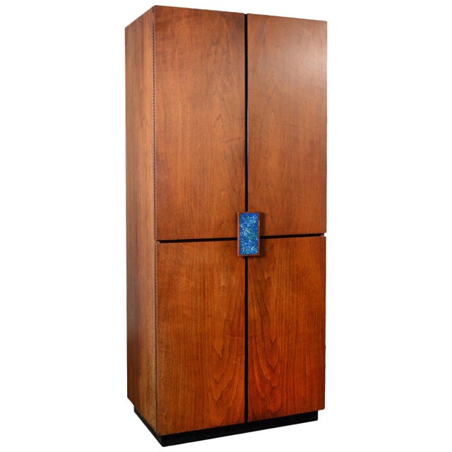Designed by Richard Thompson for Glenn of California, this walnut cabinet has four doors that conceal an upper and lower...