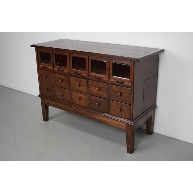 This very unique haberdashery cabinet was produced during the 1920/30s in Germany. It features 10 drawers and 5 with cut...