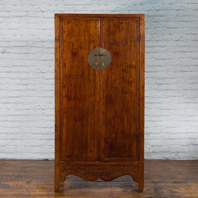 A Chinese Qing Dynasty period elm wood cabinet from the 19th century with two large doors, bronze medallion hardware,...